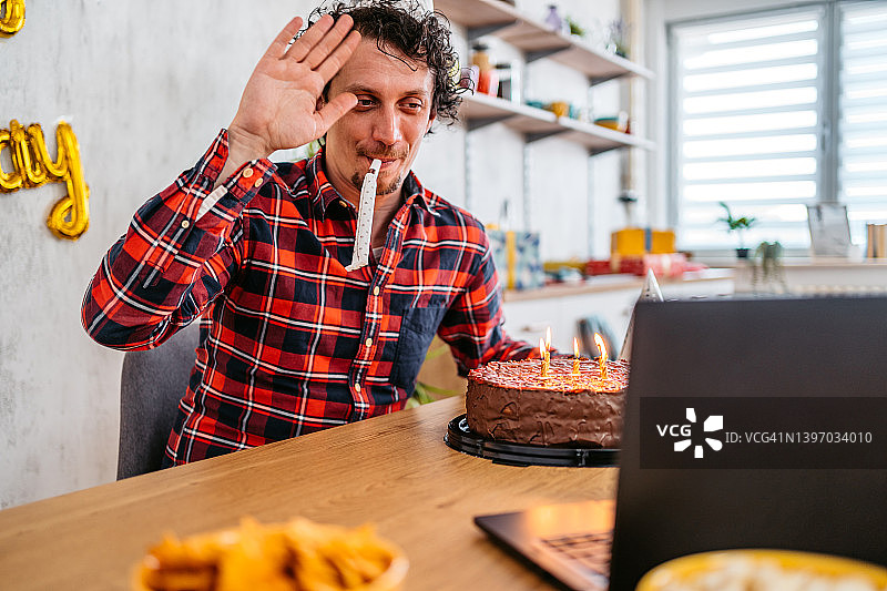 年轻男人在庆祝生日时与朋友在笔记本电脑上交谈图片素材