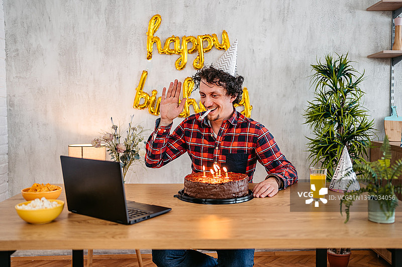 年轻男人在庆祝生日时与朋友在笔记本电脑上交谈图片素材