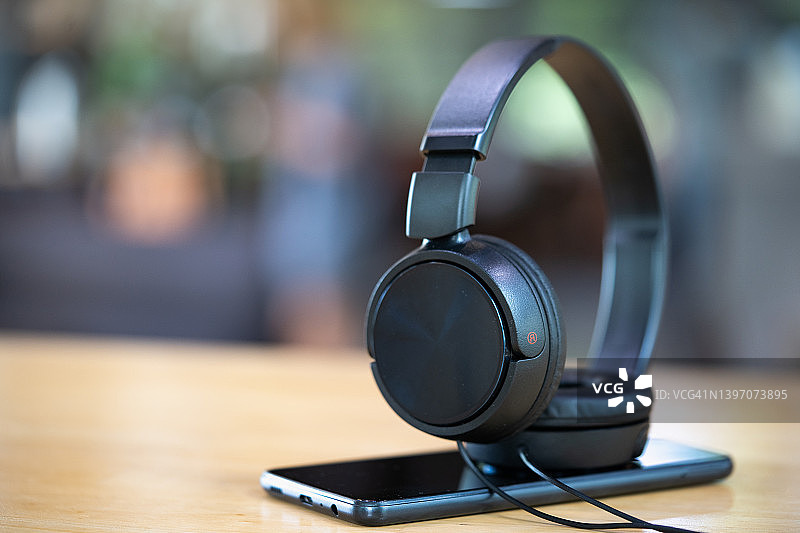 桌子上的黑色耳机和智能手机图片素材