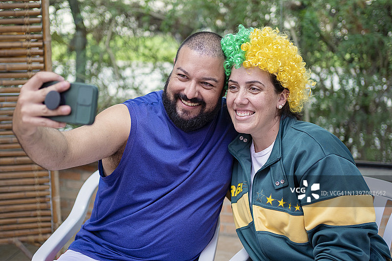 身穿巴西足球啦啦队服的异性恋情侣肖像图片素材