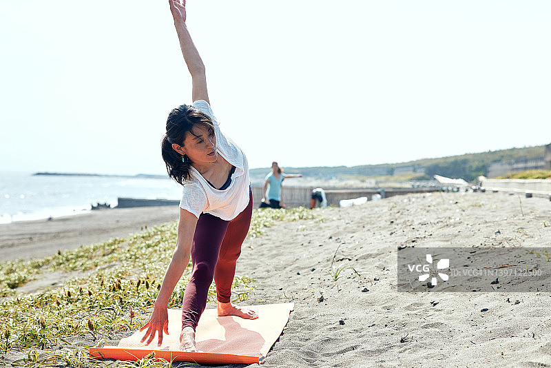 女人在海滩上做瑜伽图片素材