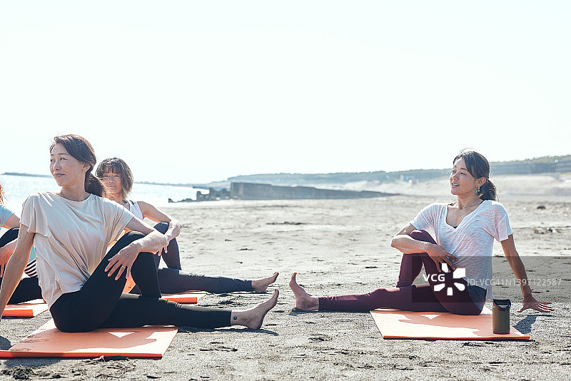 女人在海滩上做瑜伽图片素材