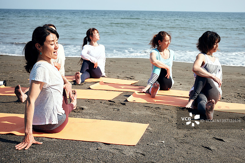 女人在海滩上做瑜伽图片素材