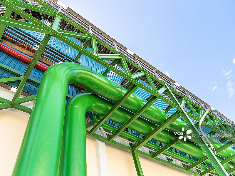 工业区的管道系统：工厂的钢制管道和阀门，化工厂、电厂、石油天然气、冷却塔中常见的泵和电机图片素材