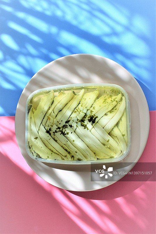 粉蓝背景下的油醋汁凤尾鱼图片素材