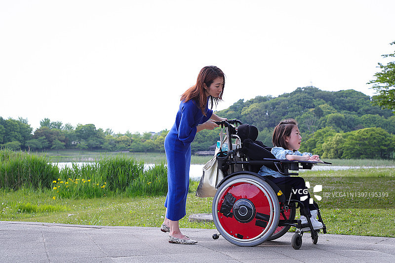 坐在轮椅上的亚裔女孩和她的母亲互动图片素材