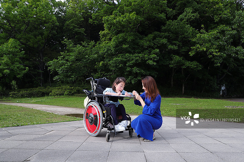坐在轮椅上的亚洲女孩和她的母亲互动图片素材