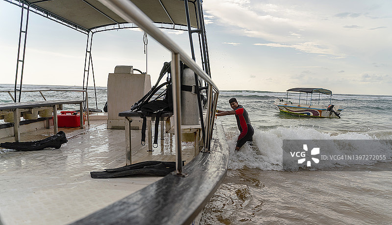斯里兰卡男子在岸边冲浪时拿着船图片素材