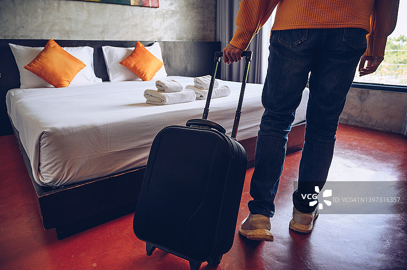 游客办理入住后将行李箱拉入酒店卧室的局部镜头图片素材
