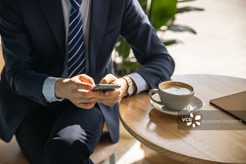 商务人士在咖啡馆用手机交流图片素材