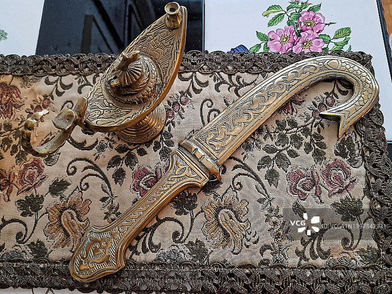 手工民族物品，阿拉丁神灯和大马士革纸刀在华丽的垫子上图片素材