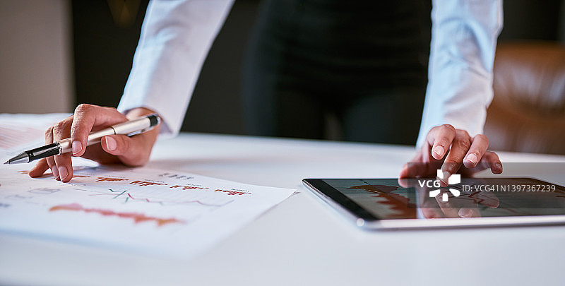 混血女商人用平板电脑监控自由职业初创公司的进度图表图片素材