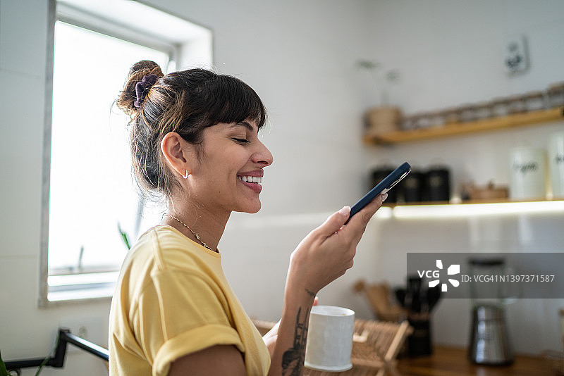 年轻女子在家用手机通话图片素材