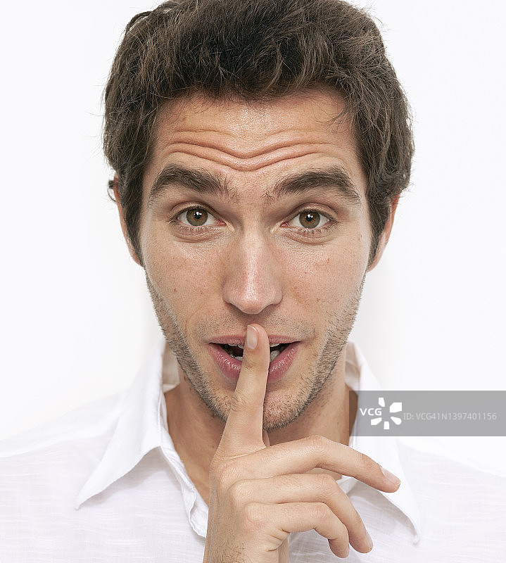 食指放在嘴唇上的英俊男子头像图片素材