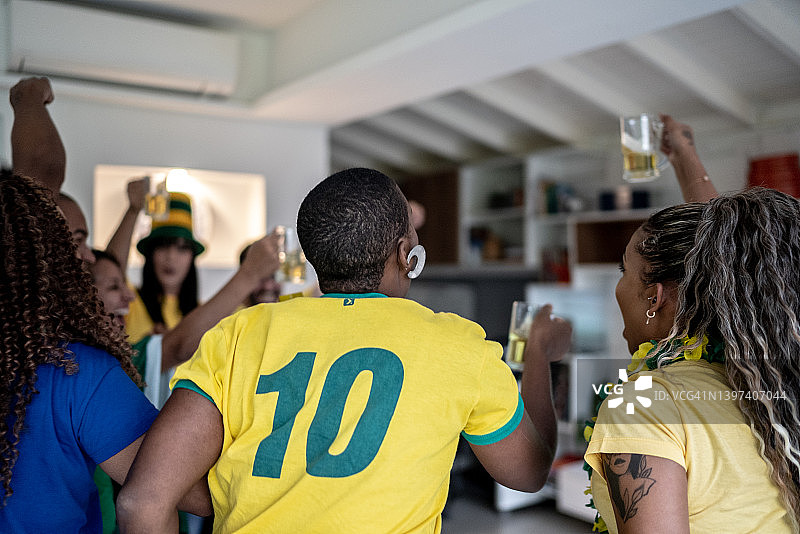 朋友们在家观看足球比赛庆祝进球图片素材