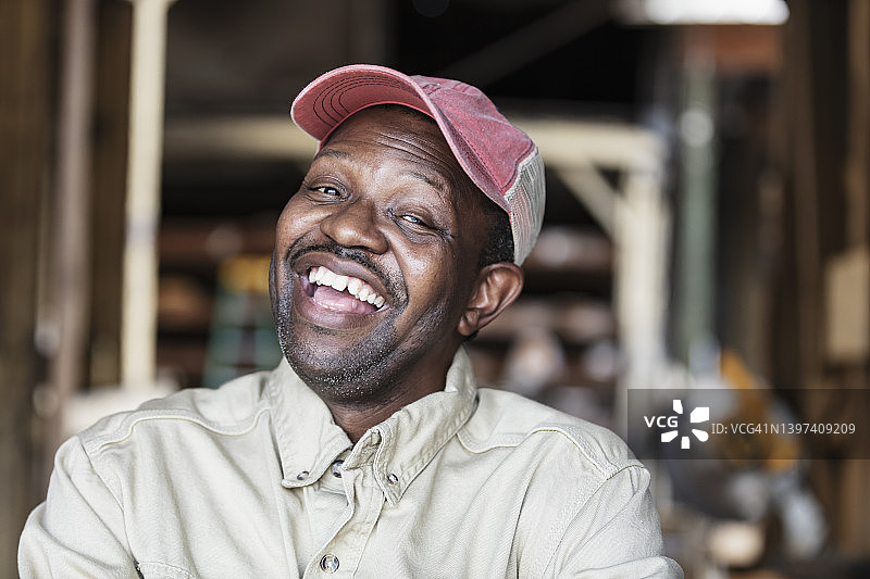 在木材厂戴着卡车司机帽的非裔男性图片素材