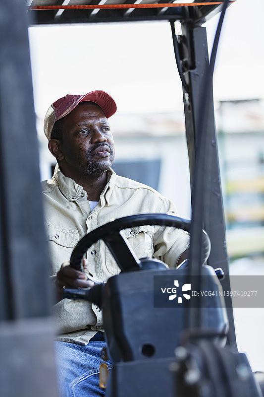 非裔美国男人在木材厂的叉车上工作图片素材