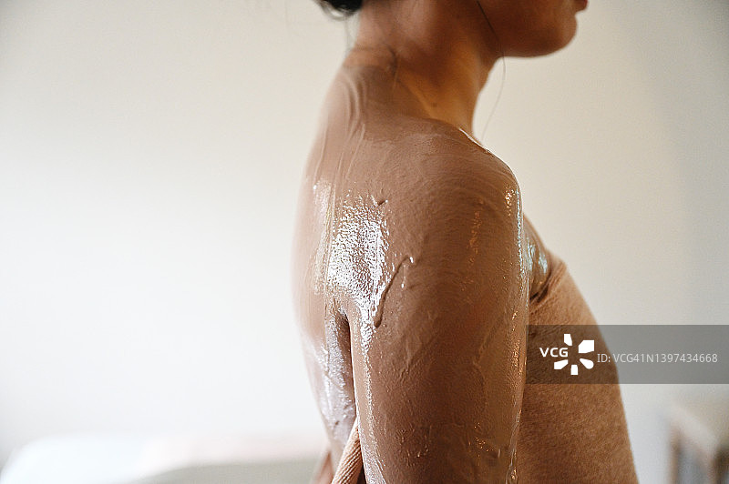 涂有泥浆面膜的女子背部特写图片素材