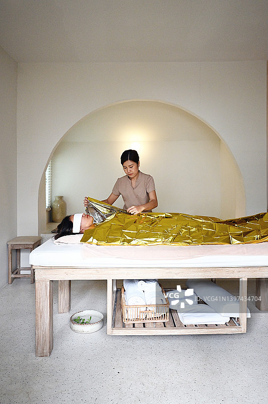 理疗师在SPA馆进行泥浆护理图片素材