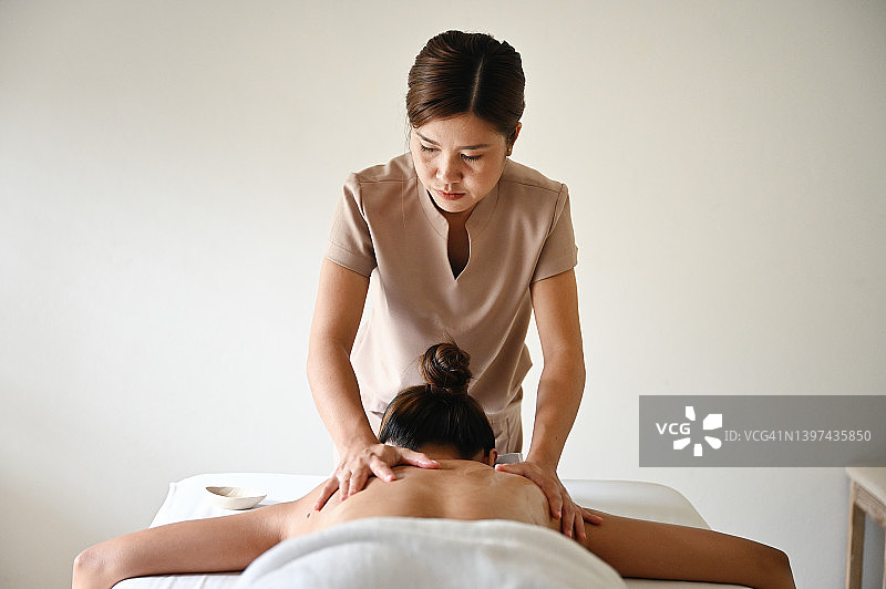 女子在豪华水疗中心为顾客按摩图片素材