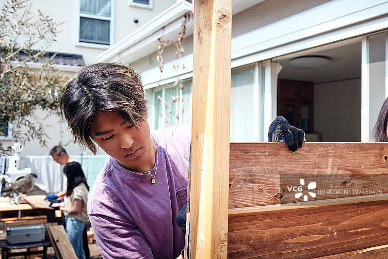 全家一起在家的木制甲板上建造仓库图片素材