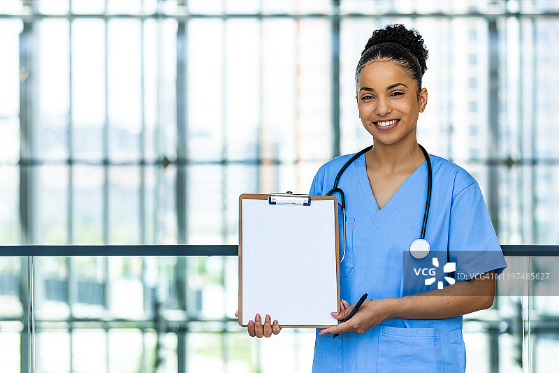 一位拿着剪贴板的有魅力的年轻女护士图片素材