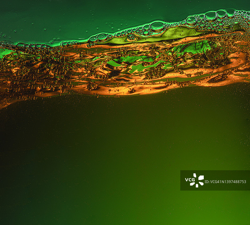 绿色液体上方的金色气泡表面图片素材