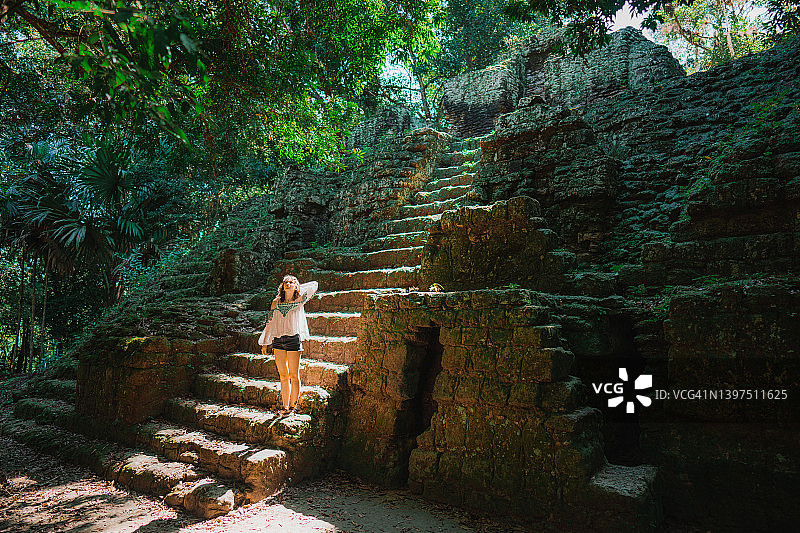 女人站在蒂卡尔国家公园金字塔的台阶上图片素材