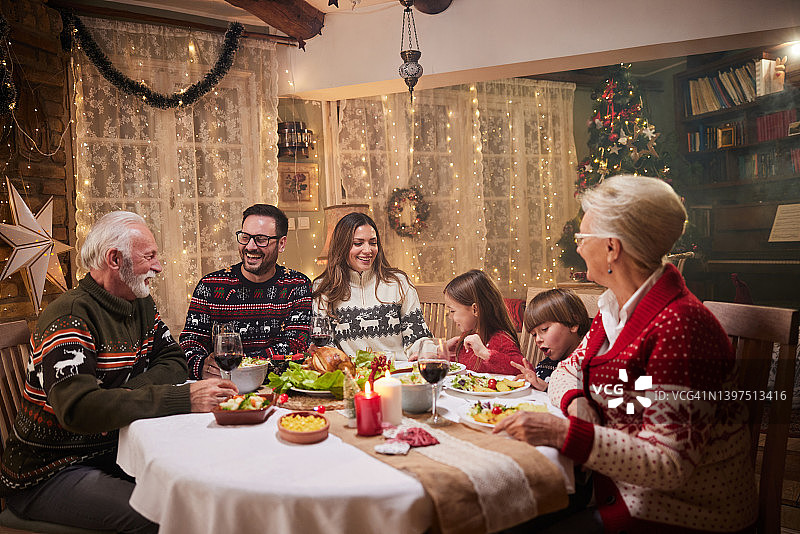 快乐的几代人在餐桌上享用圣诞晚餐图片素材