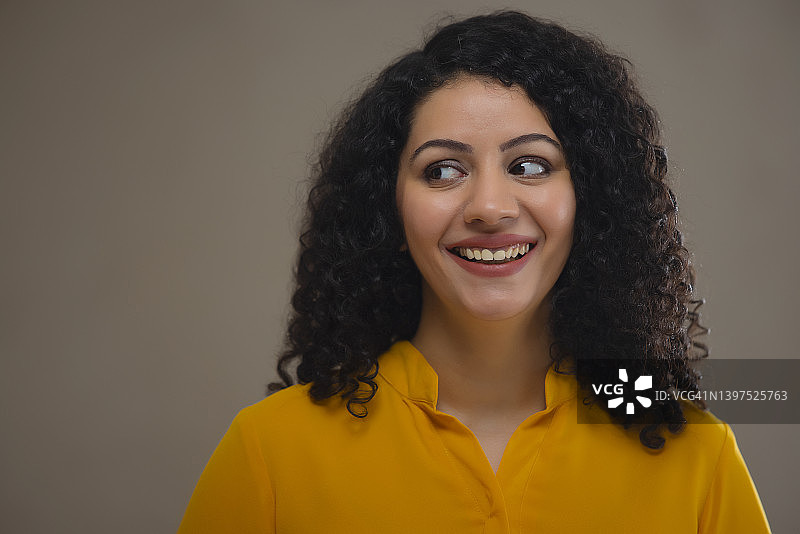 身穿黄色服装的年轻女子斜视图片素材