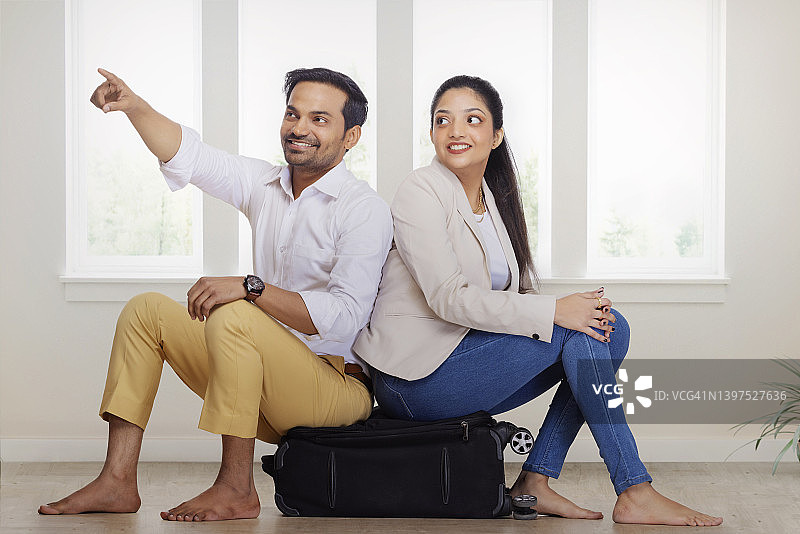 情侣坐在行李箱上准备旅行图片素材