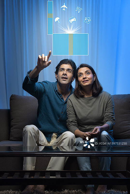 印度中年夫妇坐在沙发上憧憬未来图片素材