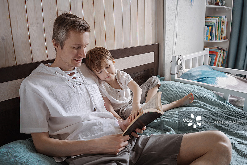 父子在卧室的床上读书图片素材