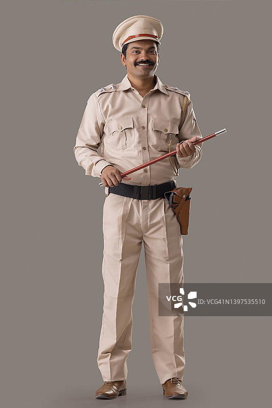 手持警棍站立的印度警察肖像图片素材