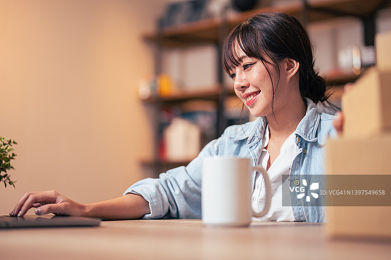 女人在家用手机/笔记本电脑网上购物图片素材