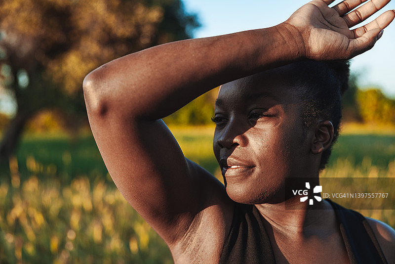 被阳光遮住脸的黑人妇女肖像图片素材