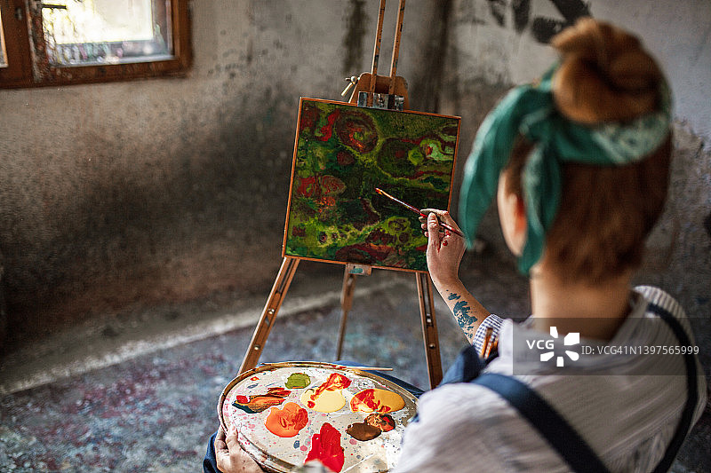 在家庭艺术工作室绘画的年轻白人女性图片素材