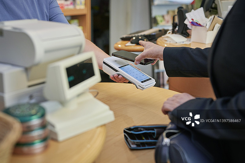 药房内顾客用手机扫码支付特写图片素材
