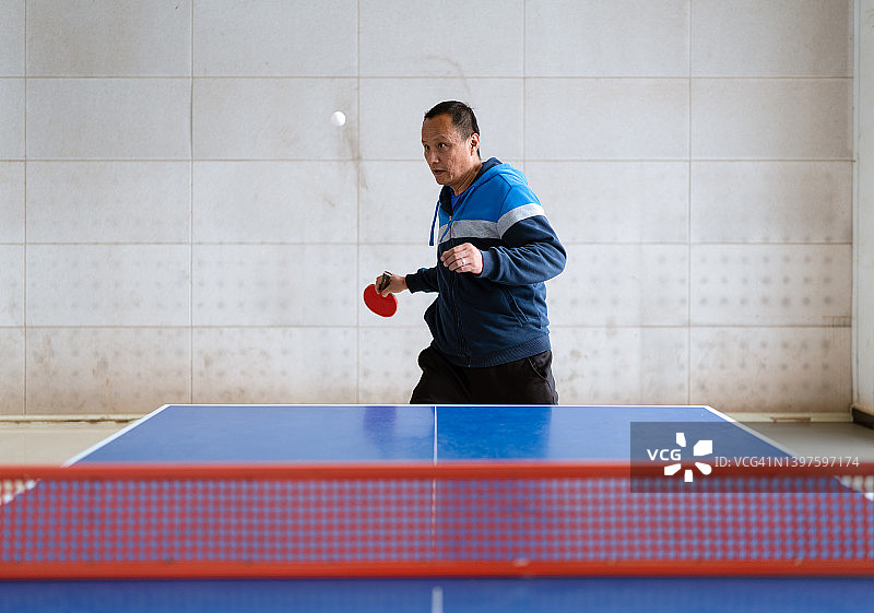 自信的亚洲男人在打乒乓球图片素材