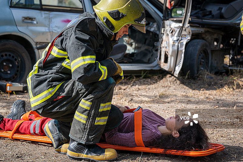 消防员或救援人员在车祸后帮助受伤妇女图片素材