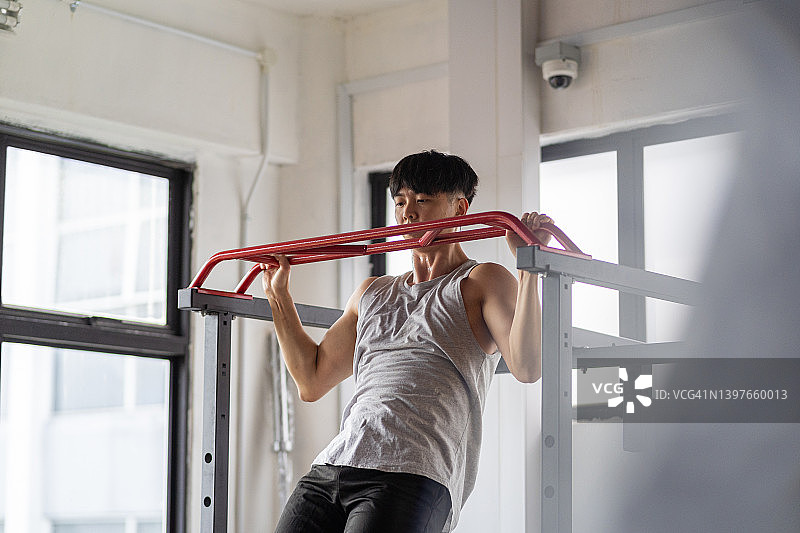 健壮的亚洲男人引体向上图片素材