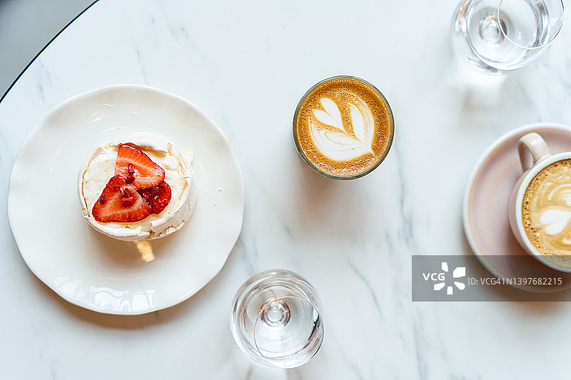 咖啡、水和草莓蛋白饼俯视图图片素材
