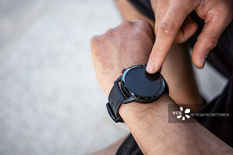 男人训练后在智能手机上查看进度（特写）图片素材