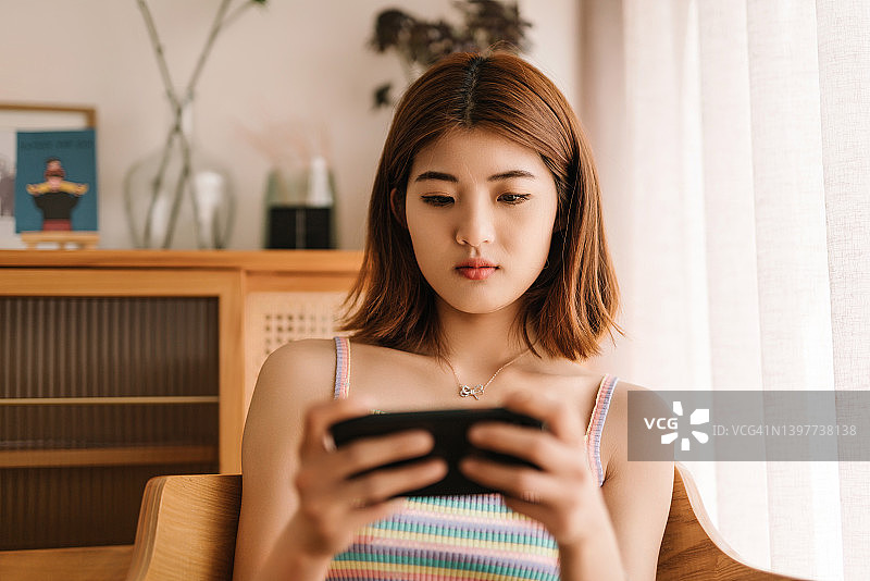 玩手机游戏的年轻亚洲女性图片素材