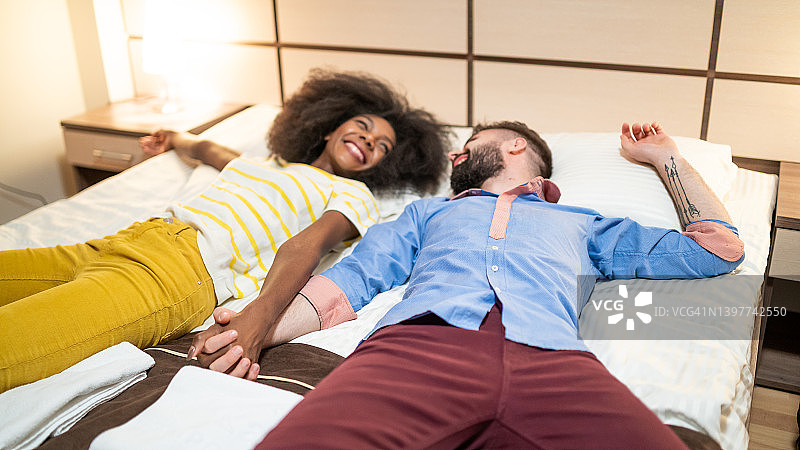 情侣在酒店房间的床上休息图片素材