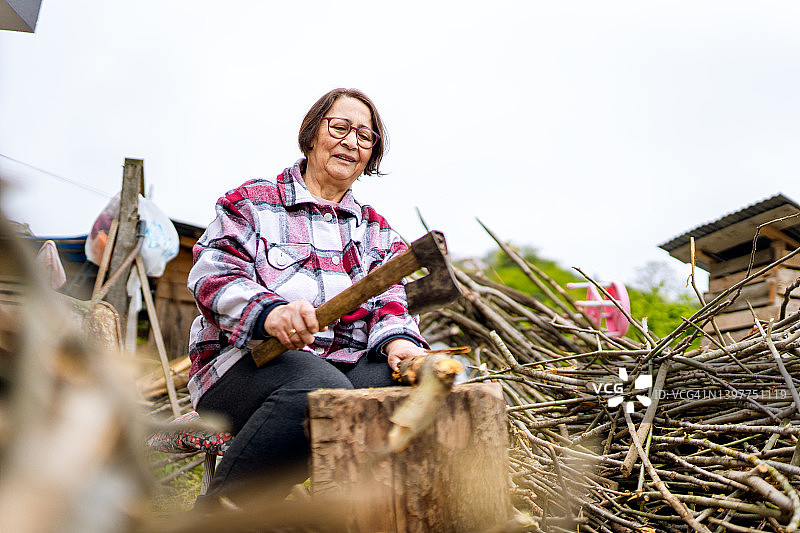 现代年老妇女砍柴的形象图片素材