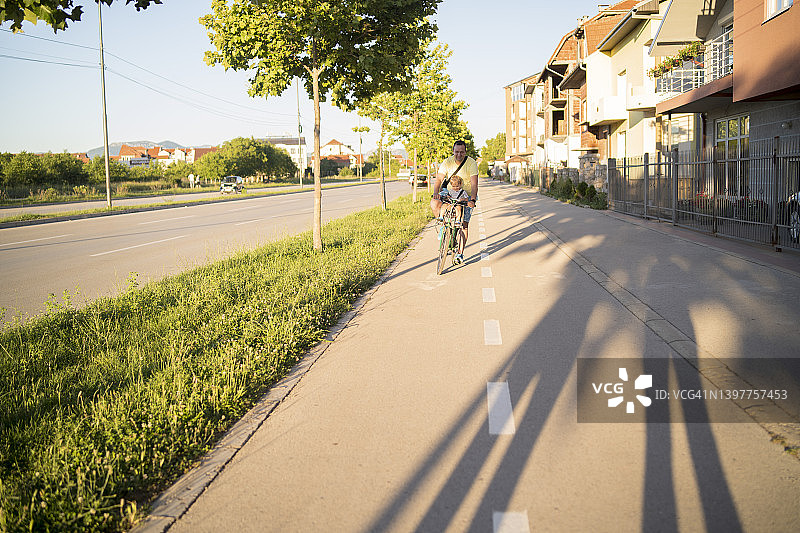 父亲用儿童座椅带着儿子骑自行车图片素材