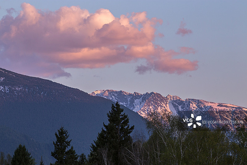 森林和山脉上的日落云彩，粉色和紫色的壮丽天空，夏季傍晚的日落图片素材