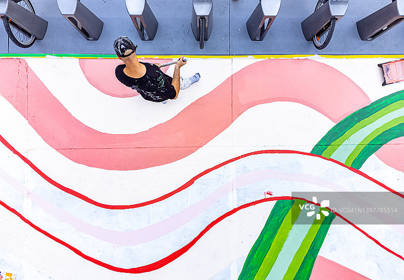 男性艺术家绘制人行道壁画的鸟瞰图图片素材