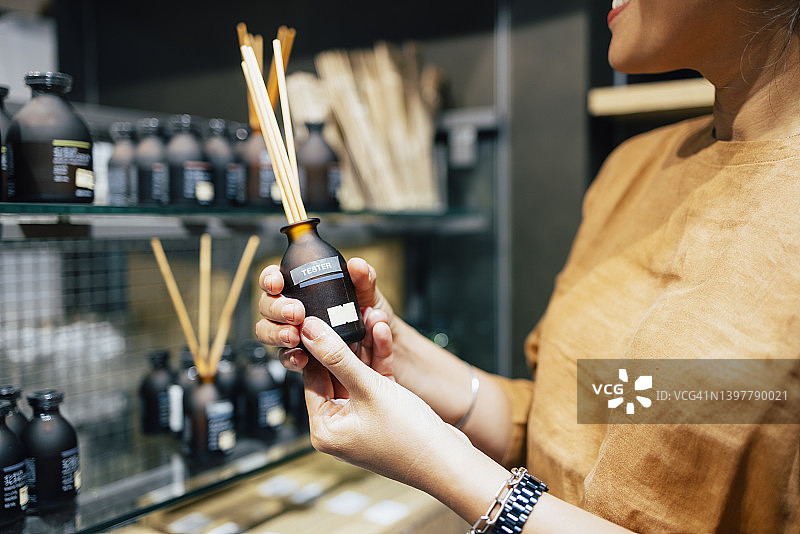 女子手持香薰，挑选购买图片素材